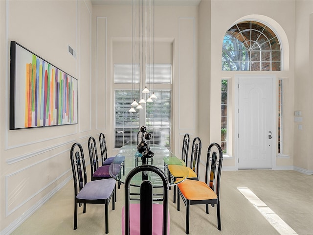 dining space featuring a towering ceiling