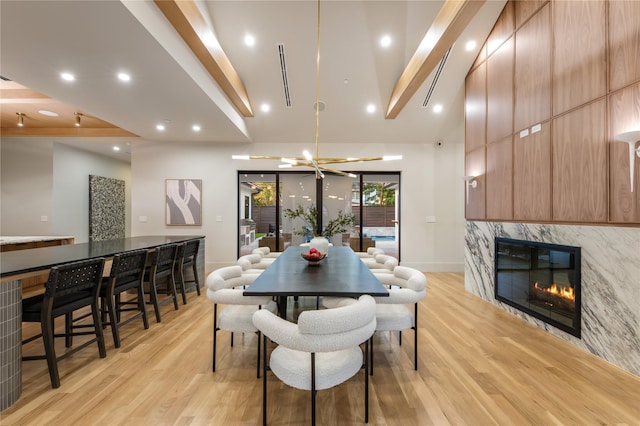 dining space featuring lofted ceiling with beams and light wood-type flooring