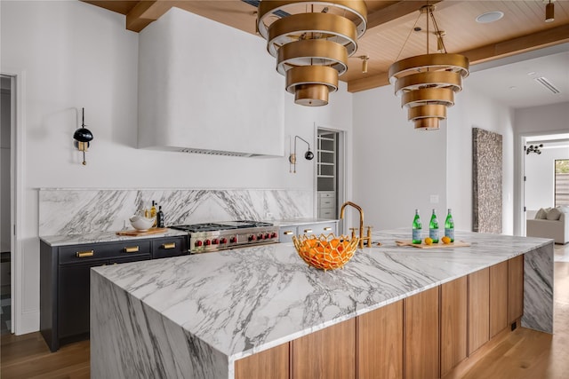 kitchen featuring wood ceiling, high end range, light stone countertops, a kitchen island, and light hardwood / wood-style flooring