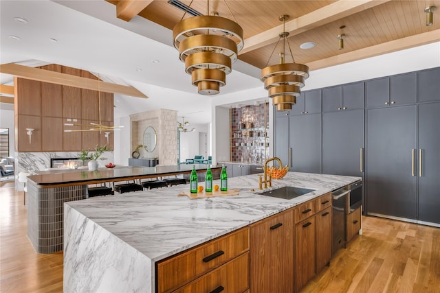 kitchen with beam ceiling, a spacious island, and sink