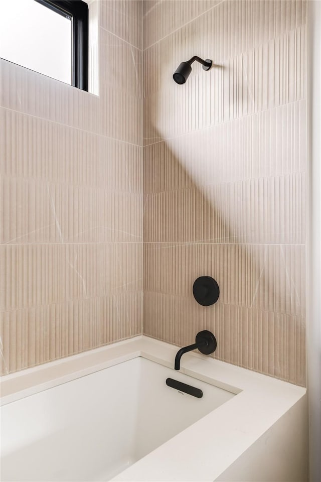 bathroom featuring tiled shower / bath