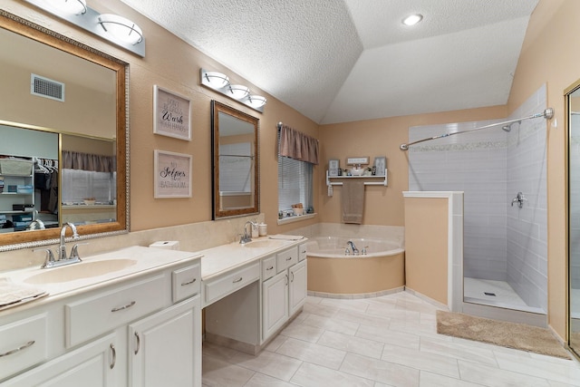 bathroom with a textured ceiling, lofted ceiling, tile patterned floors, vanity, and independent shower and bath