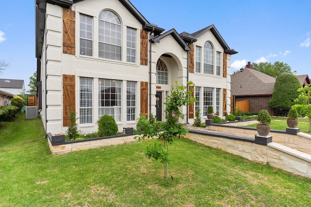 view of front of home featuring a front yard and central AC