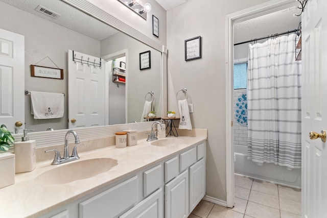 bathroom featuring a textured ceiling, tile patterned floors, vanity, and shower / tub combo