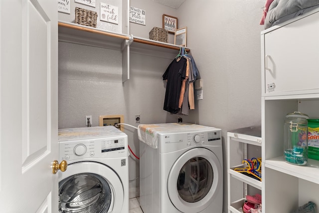 clothes washing area with washer and dryer and cabinets