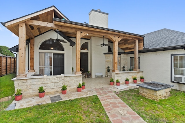 back of house featuring ceiling fan, an outdoor fire pit, a yard, and a patio