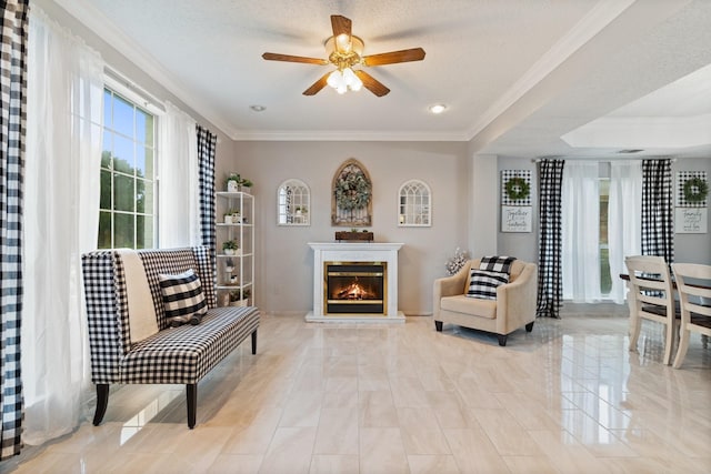 sitting room featuring a textured ceiling, ceiling fan, and crown molding