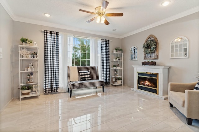 sitting room with a textured ceiling, ceiling fan, and ornamental molding