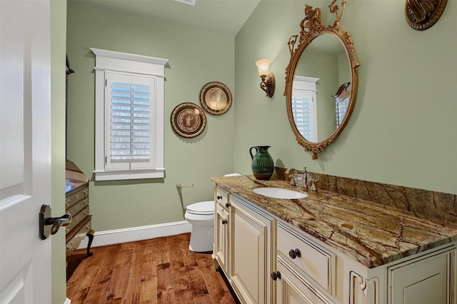 bathroom with toilet, vanity, and hardwood / wood-style flooring