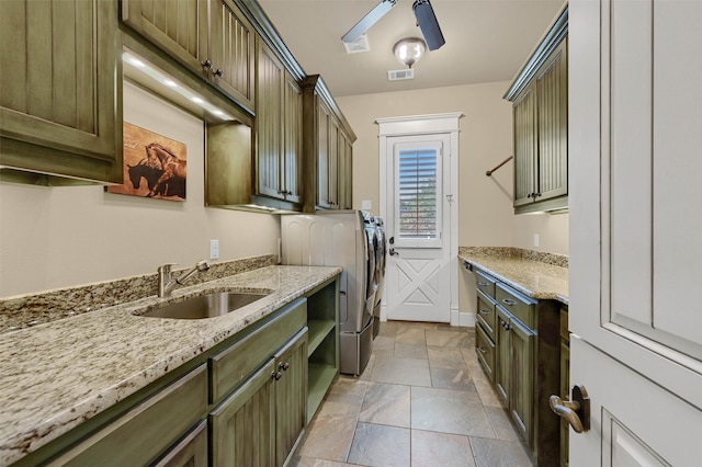 laundry area with ceiling fan, independent washer and dryer, sink, and cabinets