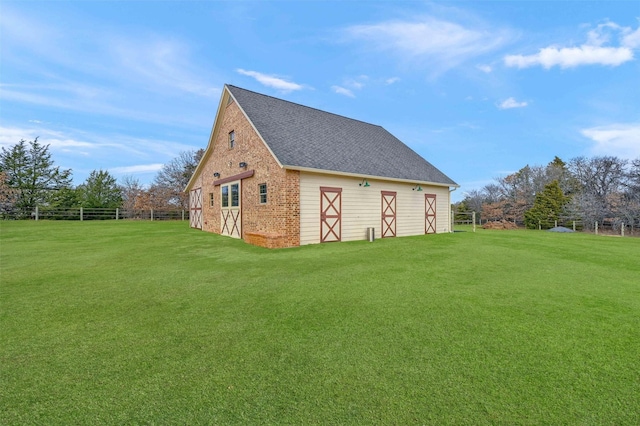 view of side of property featuring a lawn and an outdoor structure