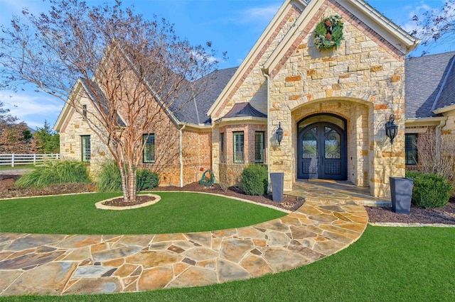 tudor-style house with a front lawn and french doors