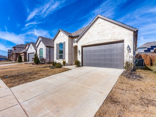 view of front of home featuring a front yard, central air condition unit, and a garage