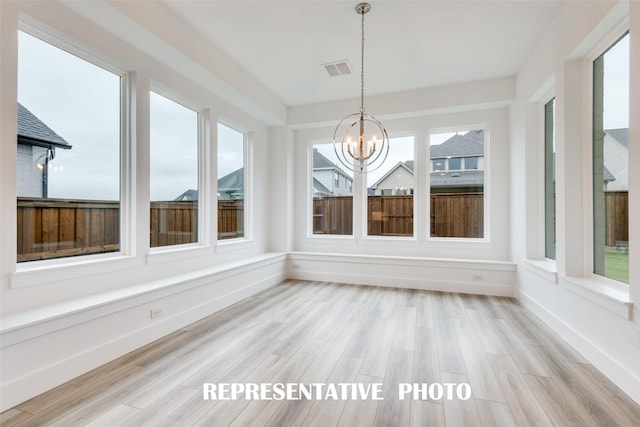 unfurnished sunroom featuring an inviting chandelier