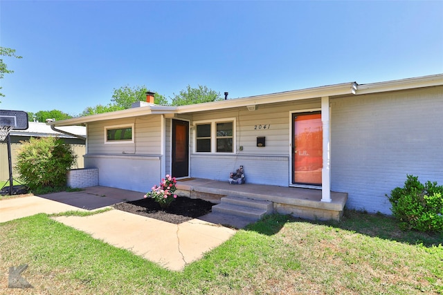 single story home with covered porch and a front yard