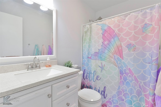 bathroom featuring toilet, vanity, and walk in shower