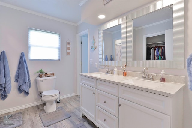 bathroom with wood-type flooring, toilet, vanity, and crown molding