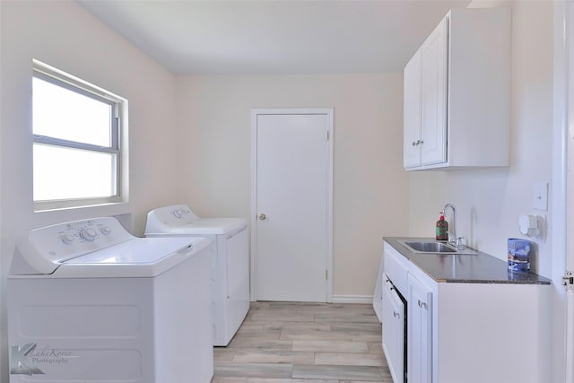 laundry room with washer and dryer, light wood-type flooring, sink, and cabinets