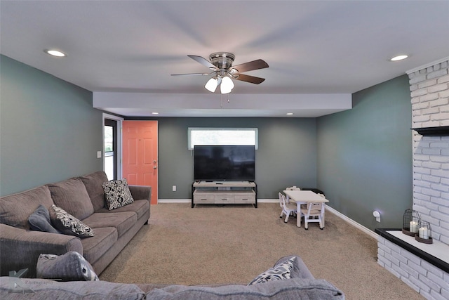 living room with ceiling fan, a brick fireplace, light carpet, and a healthy amount of sunlight