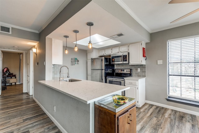 kitchen with tasteful backsplash, appliances with stainless steel finishes, sink, and white cabinetry