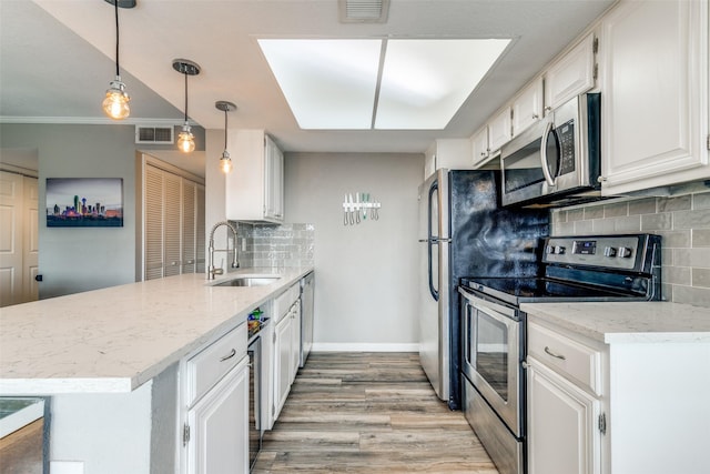 kitchen featuring white cabinets, decorative backsplash, appliances with stainless steel finishes, and sink