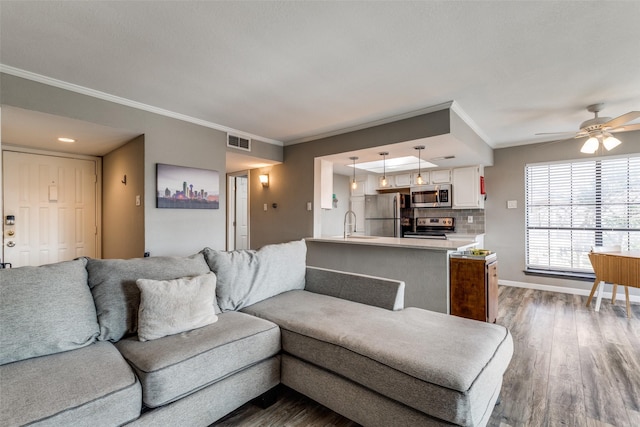 living room with ceiling fan, dark hardwood / wood-style floors, and crown molding