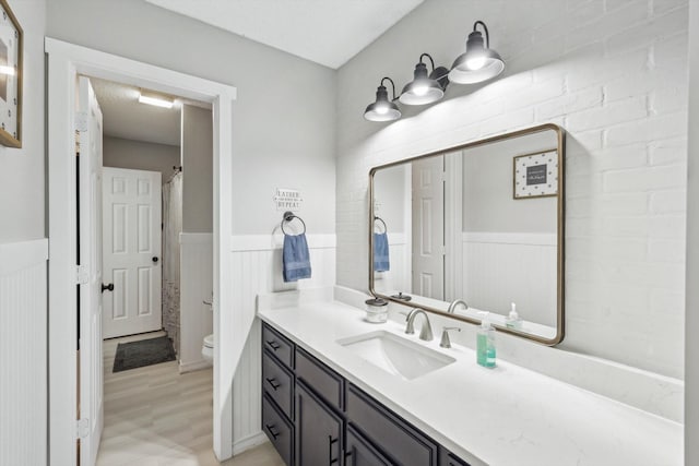 bathroom with toilet, hardwood / wood-style flooring, and vanity