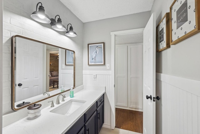 bathroom featuring wood-type flooring, a textured ceiling, and vanity