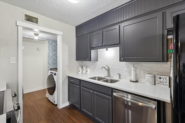 kitchen featuring washer / dryer, sink, stainless steel appliances, a textured ceiling, and dark hardwood / wood-style flooring