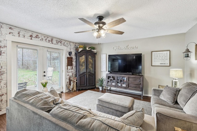 living room featuring a textured ceiling, dark wood-type flooring, and french doors