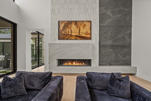 living room featuring a high end fireplace and hardwood / wood-style flooring