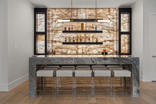 bar with hardwood / wood-style floors