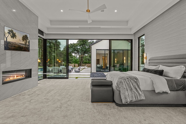 bedroom with access to outside, ceiling fan, a tiled fireplace, and carpet flooring