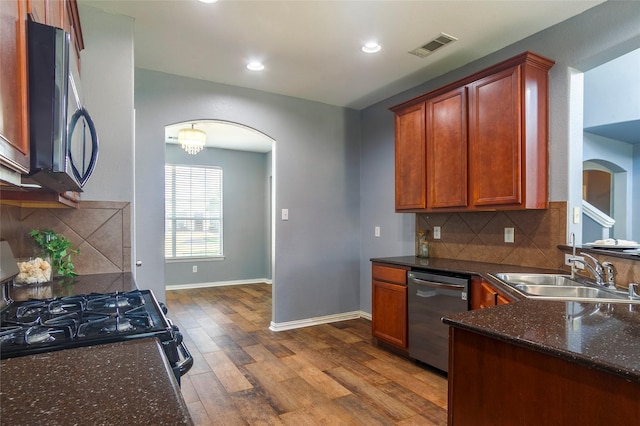 kitchen featuring sink, hardwood / wood-style flooring, dishwasher, backsplash, and gas stove