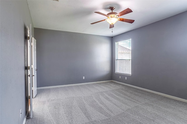 carpeted spare room featuring ceiling fan