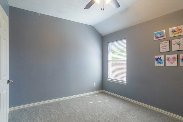 empty room with ceiling fan, lofted ceiling, and carpet