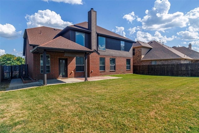 rear view of house featuring a lawn and a patio