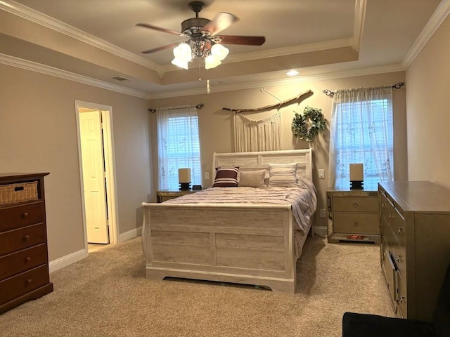 carpeted bedroom featuring ceiling fan, multiple windows, and a raised ceiling