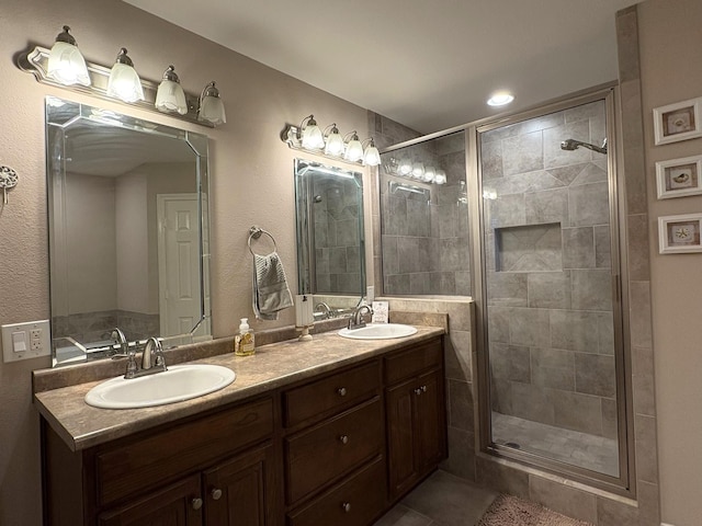 bathroom featuring a shower with shower door, vanity, and tile patterned floors