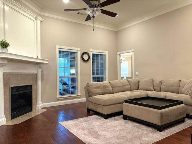 living room with hardwood / wood-style flooring, crown molding, ceiling fan, and a fireplace