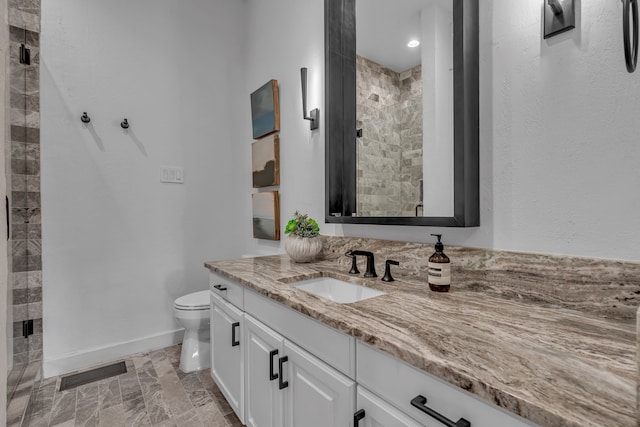 bathroom with walk in shower, vanity, and toilet