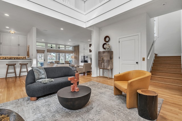 living room featuring recessed lighting, stairway, and light wood-style flooring