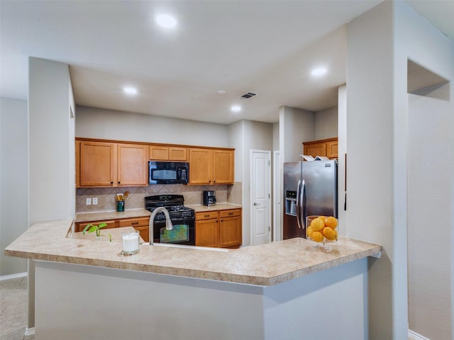 kitchen featuring decorative backsplash, kitchen peninsula, and black appliances