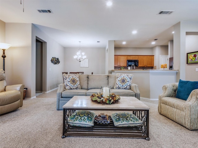 living room featuring light colored carpet and an inviting chandelier