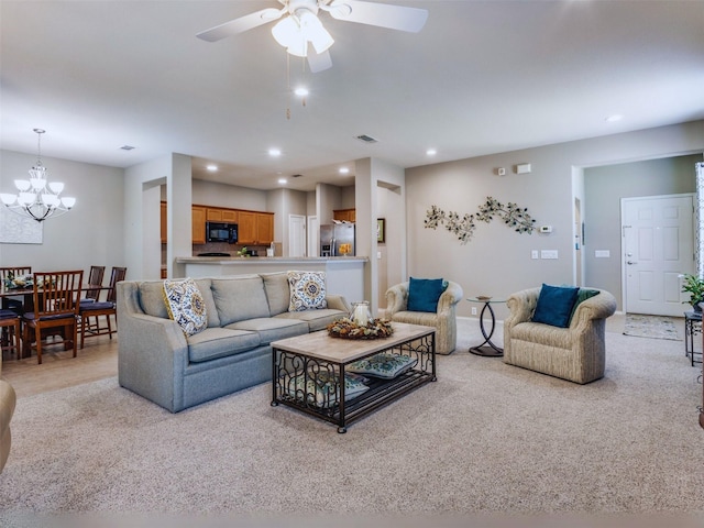 living room featuring ceiling fan with notable chandelier