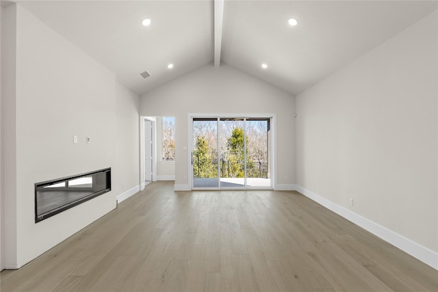 unfurnished living room with high vaulted ceiling, beam ceiling, and light wood-type flooring