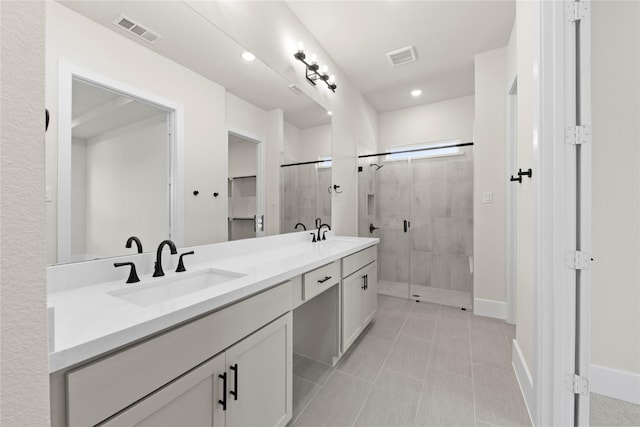 bathroom featuring tile patterned floors, a shower with shower door, and vanity