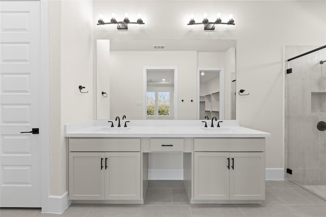 bathroom with visible vents, a sink, a shower stall, and double vanity