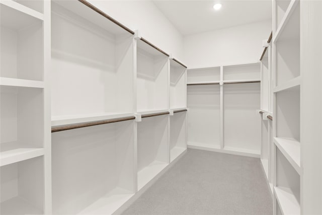 walk in closet featuring light colored carpet