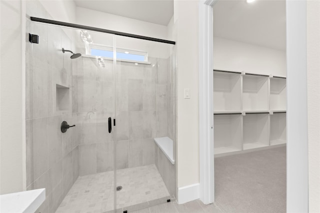 bathroom featuring a shower stall and a spacious closet